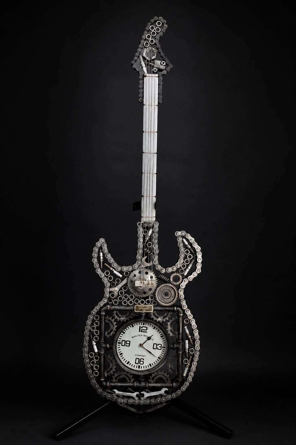 Timeless Steel — gitaarsculptuur van kettingen, tandwielen en pijp, met een werkend uurwerk in het corpus